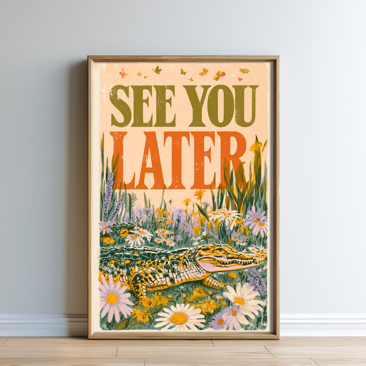The image is a framed poster with a vibrant illustration of a crocodile surrounded by flowers and plants. The text on the poster reads "SEE YOU LATER".
