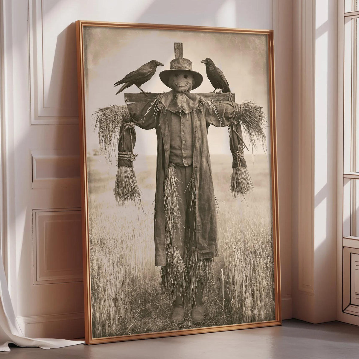 A framed black and white photograph depicting a scarecrow standing in a field, with two birds perched on its back.