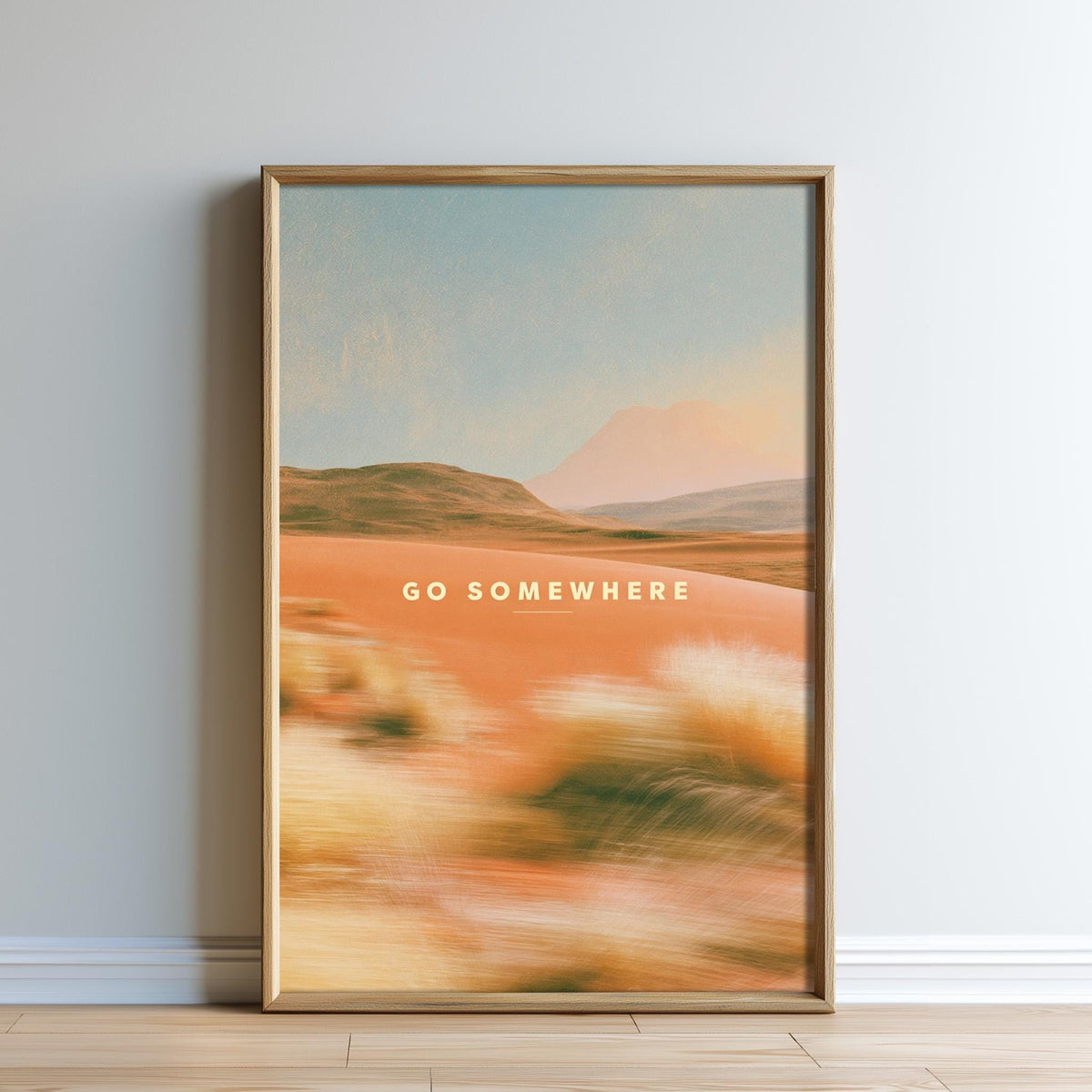 The image is a framed poster with a desert landscape and the text "GO SOMEWHERE" displayed on it.