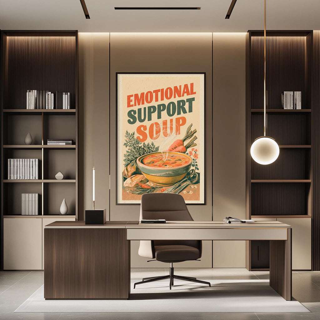 a modern office space with a large framed poster on the wall that reads "Emotional Support Soup". The poster has an illustration of a bowl of soup and the text "Emotional Support Soup" written in bold letters. The office has a wooden desk and chair, and there are bookshelves on either side of the desk.