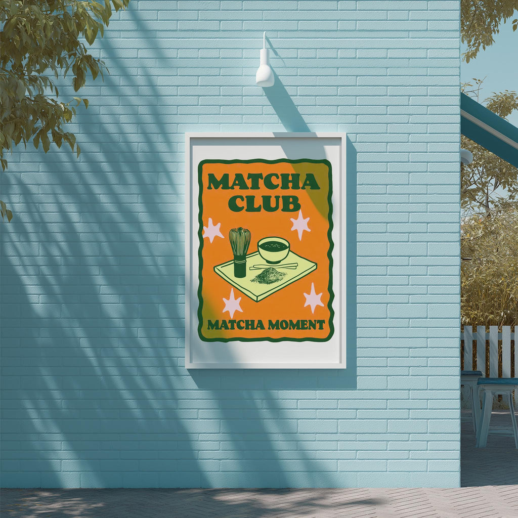 A framed poster on a blue wall advertising a "MATCHA CLUB" with a graphic of matcha and a bowl of matcha.