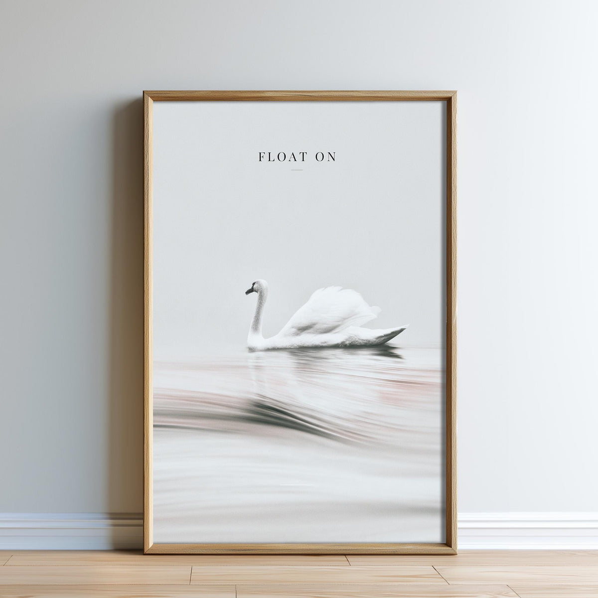 A framed image of a swan floating on a body of water, with the text "FLOAT ON" above it.