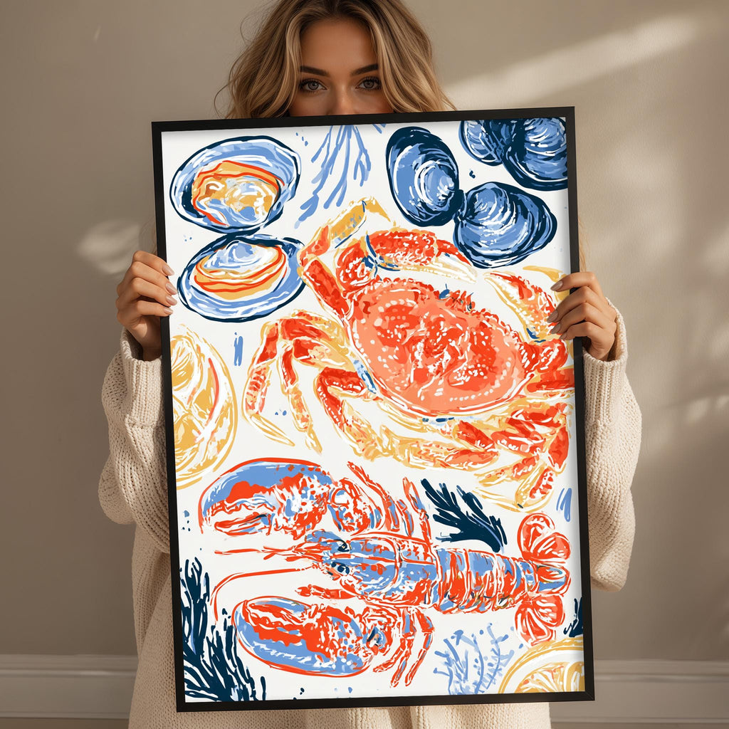 A woman is holding up a framed print with a vibrant illustration of various seafood items, including a lobster, crab, and other marine creatures.