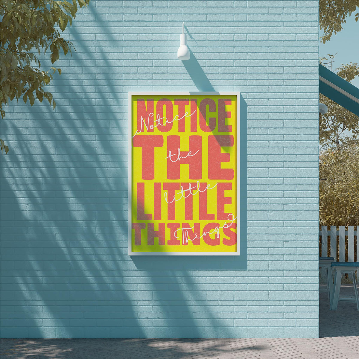 a large, colorful poster with the text "NOTICE THE LITTLE THINGS" displayed on a blue brick wall.