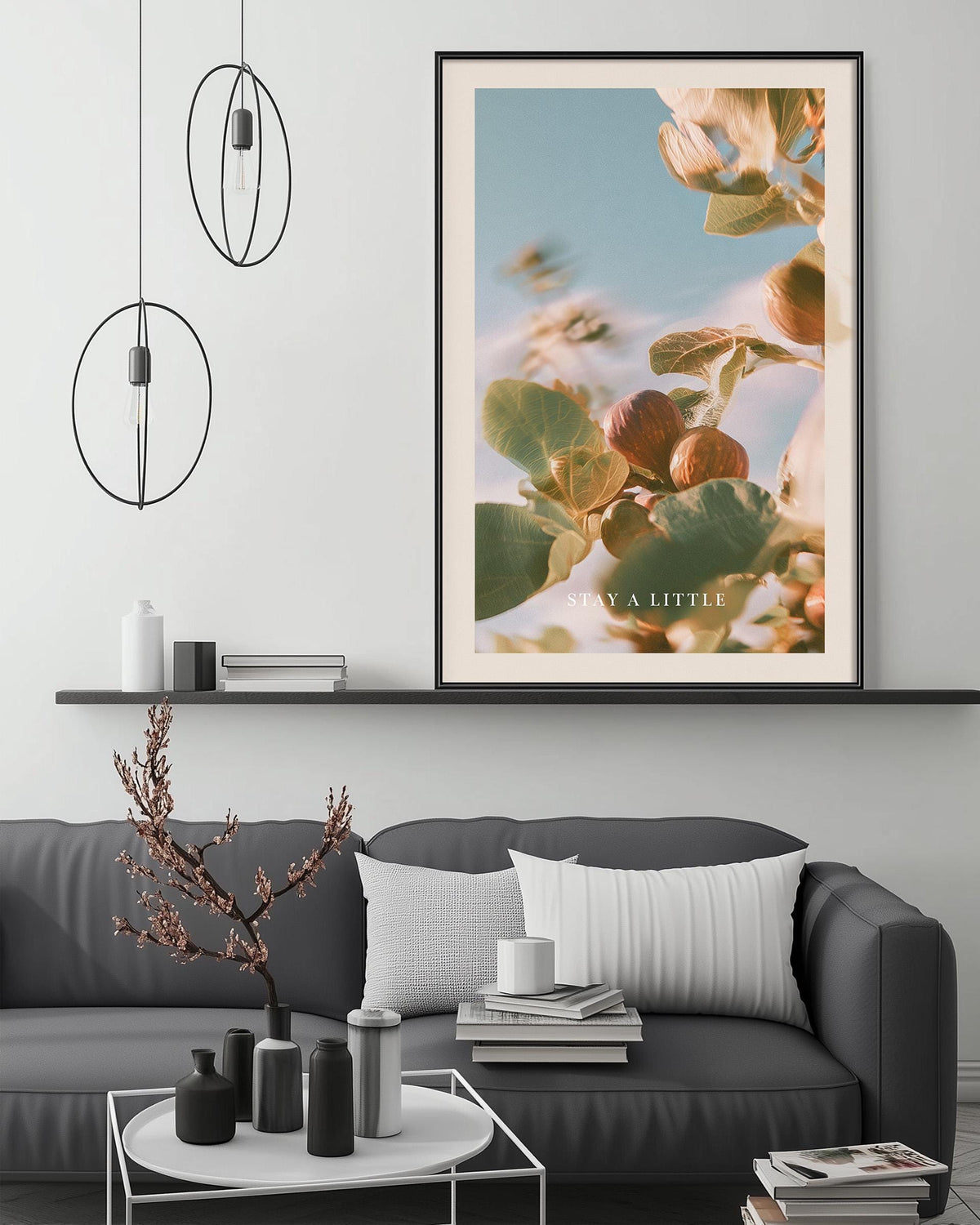 a modern living room with a gray sofa, a coffee table, and a framed poster of a plant on the wall.