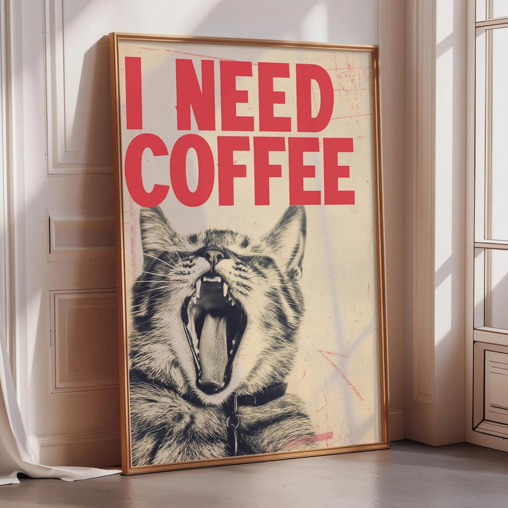 A framed poster with a cat's face and the text "I NEED COFFEE" is displayed on a wall.