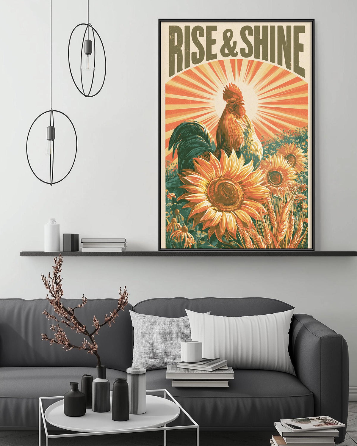 a large framed poster of a rooster surrounded by sunflowers, with the text "RISE & SHINE" prominently displayed. The poster is hanging on a wall above a gray couch, which has a coffee table in front of it. The room also contains a shelf with various decorative items, and a potted plant is visible in the foreground.