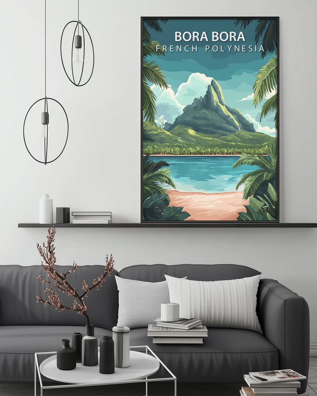 a large framed poster of a tropical island landscape, with a mountain and palm trees, hanging on a wall above a gray couch and a coffee table.
