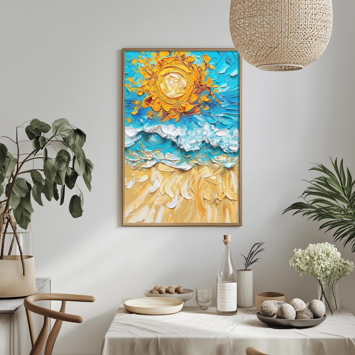 a dining table with a white tablecloth, a bowl of fruit, a bottle, and a vase with flowers. Above the table, there is a framed painting of a beach scene with a sun and waves.