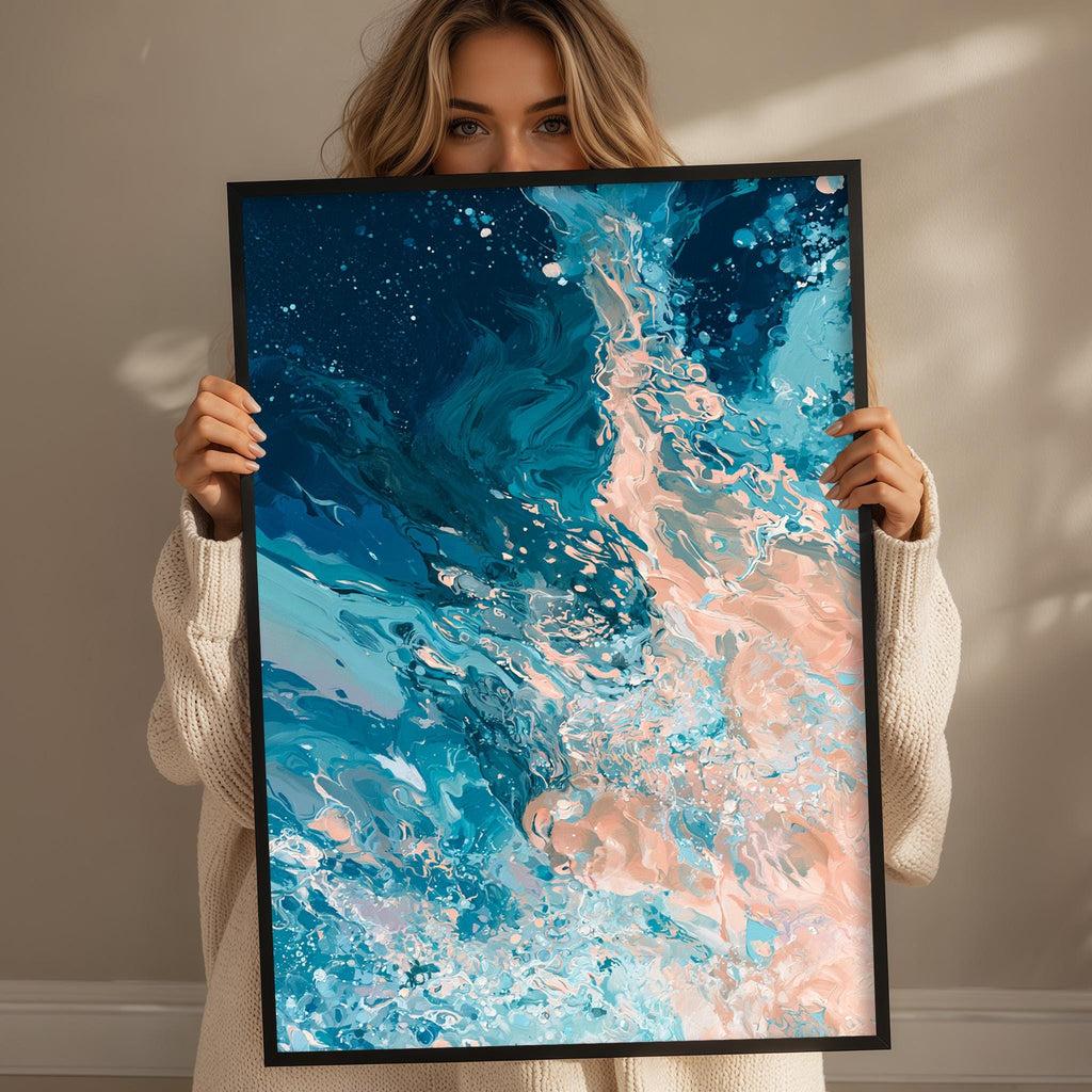 A woman is holding up a framed abstract painting with a vibrant blue and pink color scheme, depicting a swirling pattern of water and marine life.