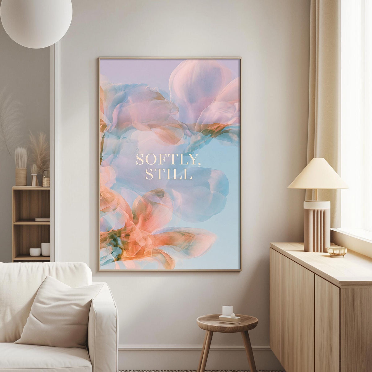 a living room with a large framed poster of a floral design on the wall, a white sofa, a wooden side table, and a lamp.