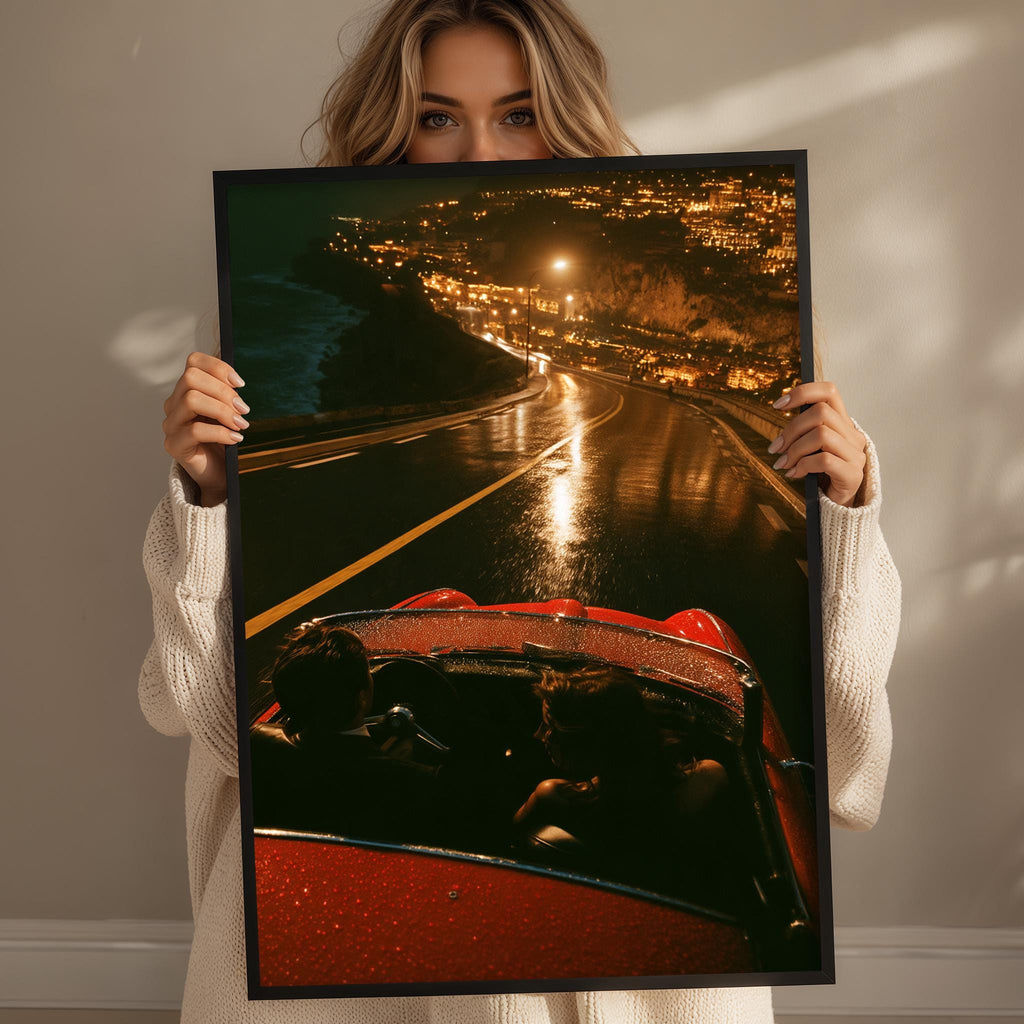 A woman holds up a framed photograph of a red convertible car on a road at night, with a cityscape visible in the background.