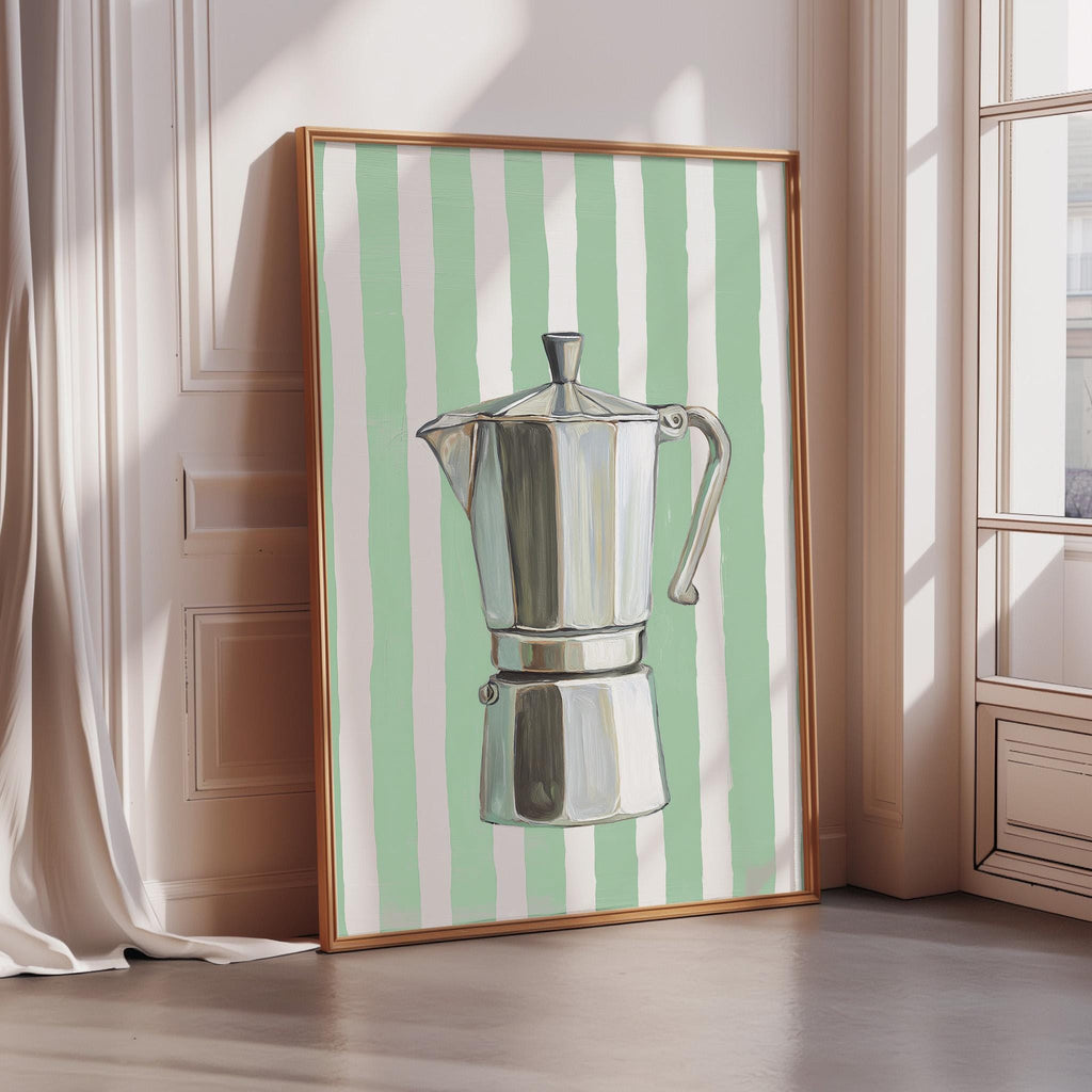 A framed painting of a silver coffee maker is displayed on a wall in a room with a window.