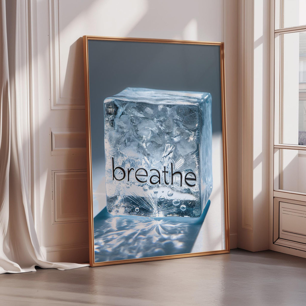 A framed image of a large ice cube with the word "breathe" written on it, placed on a wooden floor in a room with a window.