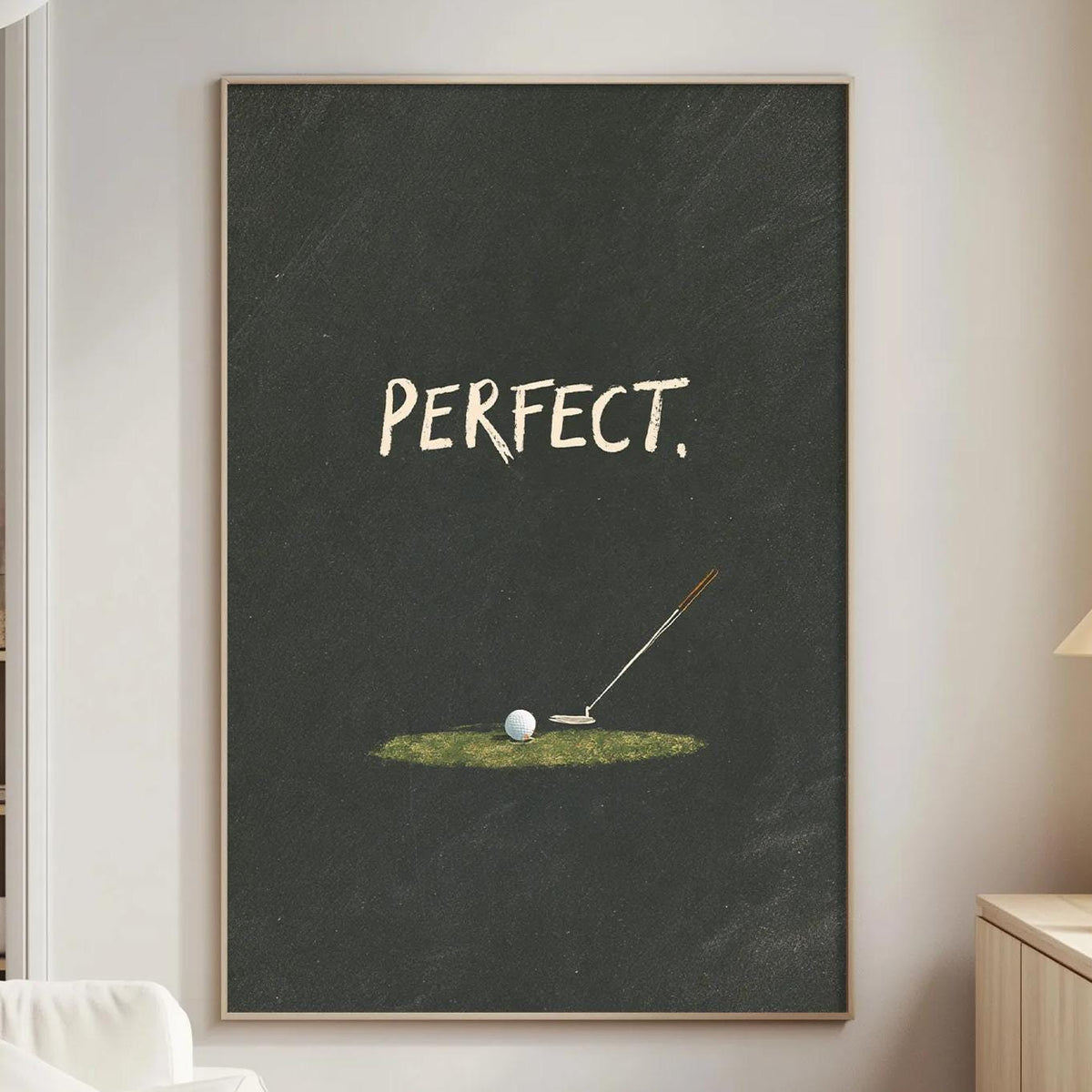 a living room with a white couch, a wooden side table, and a framed poster on the wall that says "PERFECT."