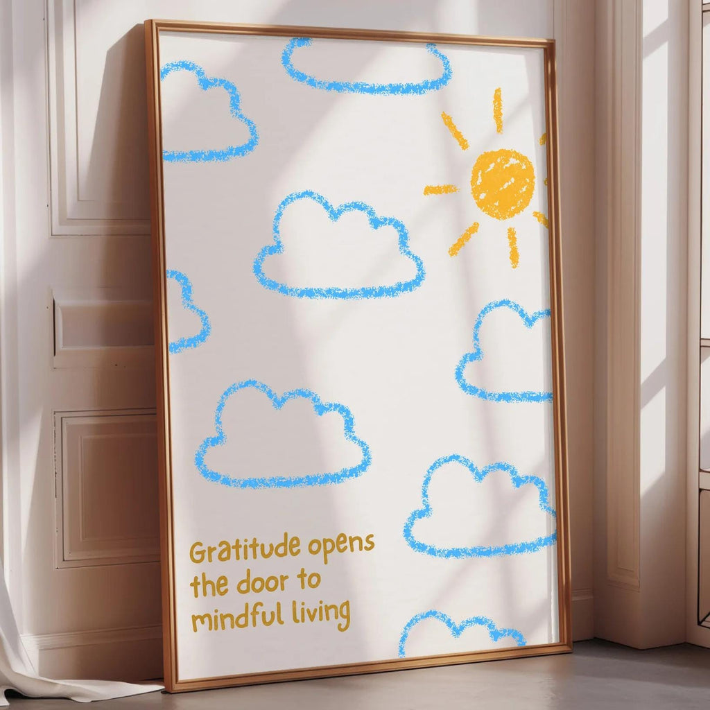 A framed poster with a drawing of clouds and a sun on a white background, placed on a wooden floor next to a window.