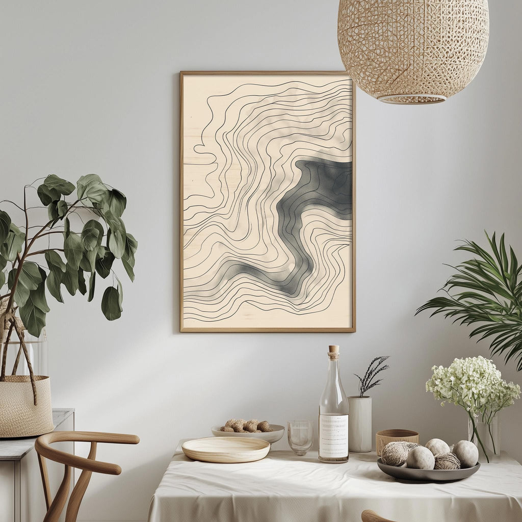 a dining table with a white tablecloth, a bowl of fruit, a bottle, and a plant. Above the table, there is a framed abstract artwork hanging on the wall.