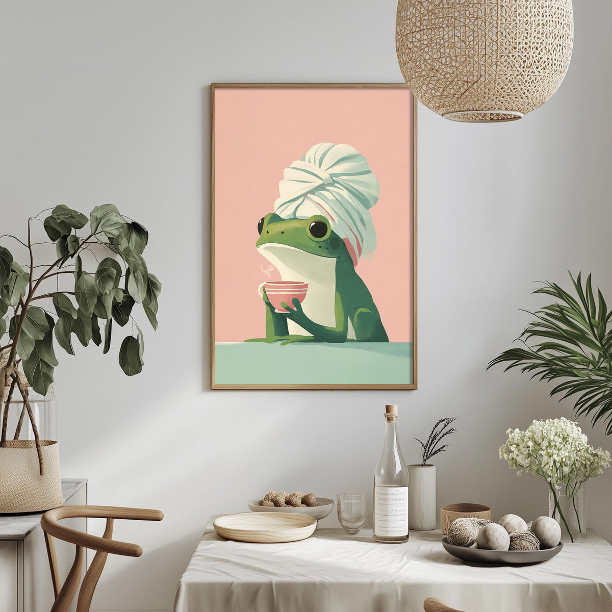 a framed illustration of a frog wearing a white towel, sitting at a table and holding a pink bowl. The table is set with various items, including a bottle, a vase, and a bowl of fruit. The room has a cozy and inviting atmosphere, with potted plants and a hanging light fixture.