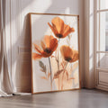 a large framed picture of orange flowers on a white wall.