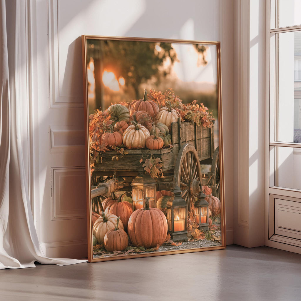 A large framed print depicting a rustic wooden wagon filled with pumpkins and autumn decorations, set against a backdrop of a tree and a sunset.
