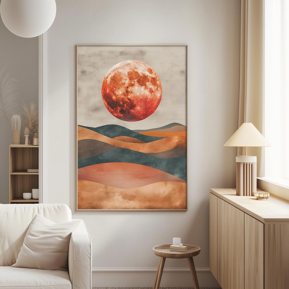 a large, abstract painting of a red moon against a mountainous landscape. The painting is hanging on a wall in a living room setting, with a white couch and a wooden side table nearby.