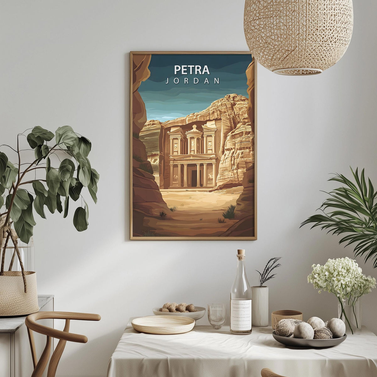 a framed poster of the ancient ruins of Petra, Jordan, hanging on a wall in a room with a dining table, chairs, and potted plants.