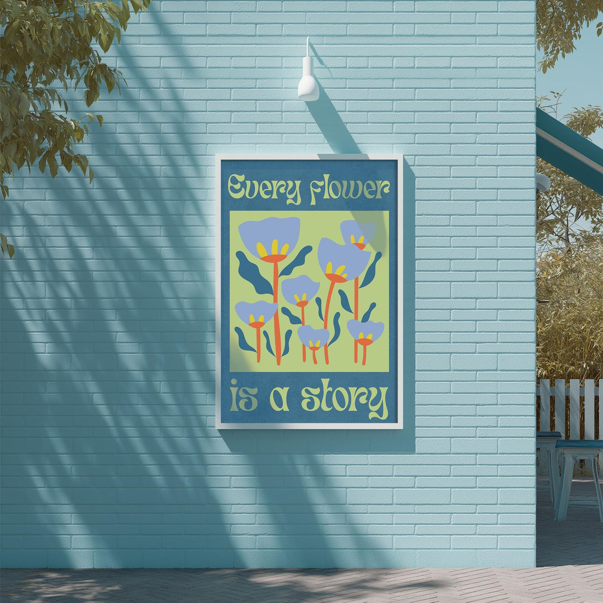 a blue brick wall with a framed poster that displays a colorful illustration of flowers and the text "Every flower is a story".