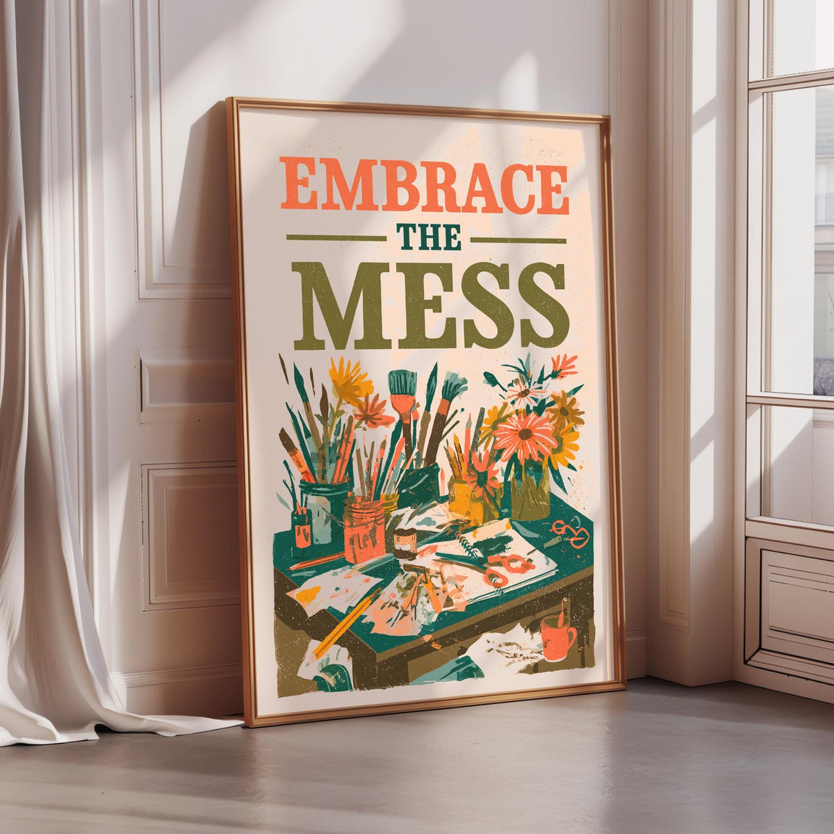 The image is a framed poster with the text "Embrace the mess" and an illustration of a cluttered workspace with various art supplies and a vase of flowers.