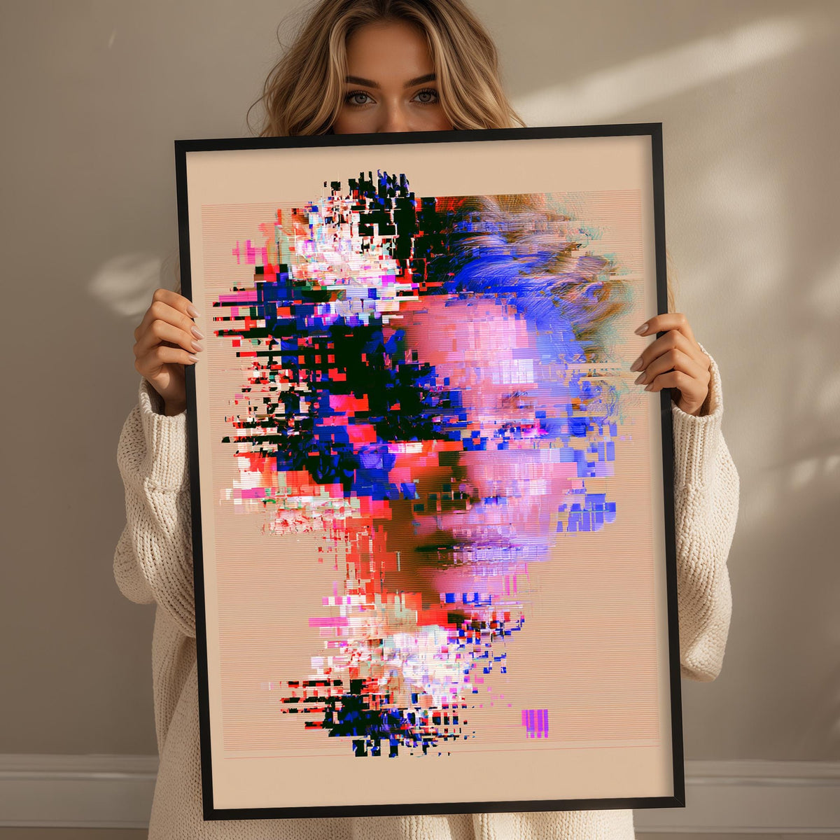 A woman holding a framed digital artwork depicting a colorful, abstract face.