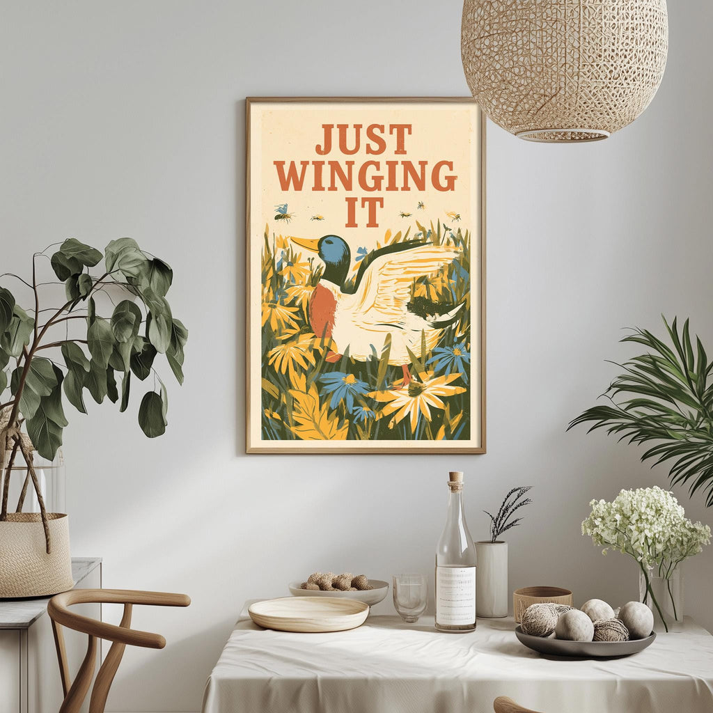a framed poster with a duck and flowers hanging on a wall above a table with various items on it.