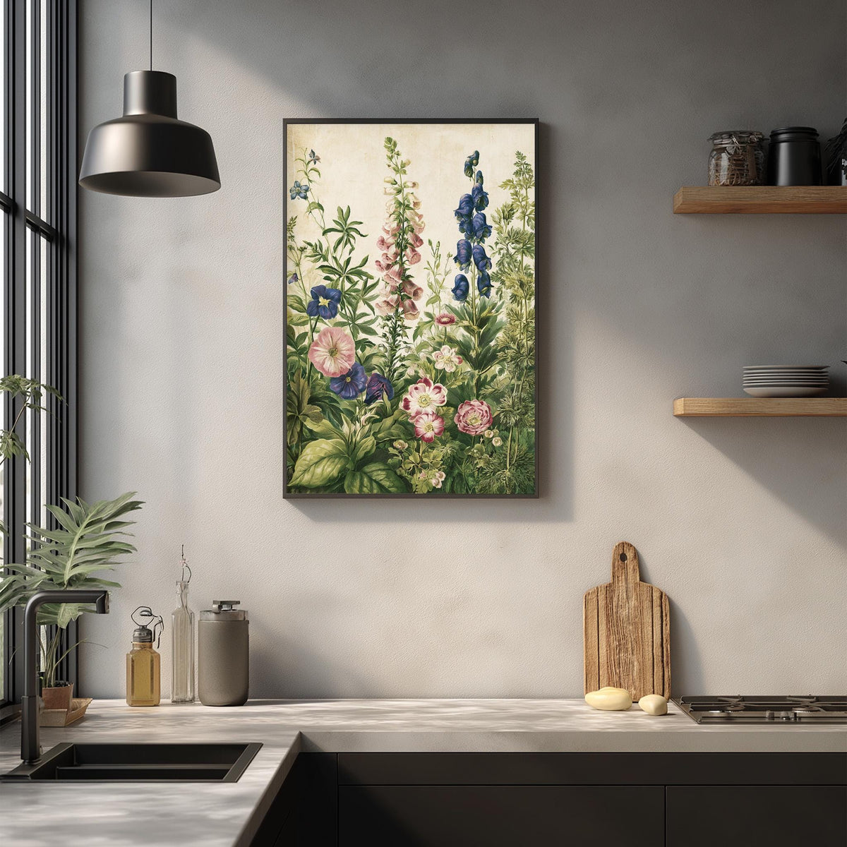 a kitchen counter with a framed painting of flowers hanging above it. The painting depicts a lush garden scene with various flowers and plants. The kitchen counter also has a cutting board, a soap dispenser, and some other kitchen items.