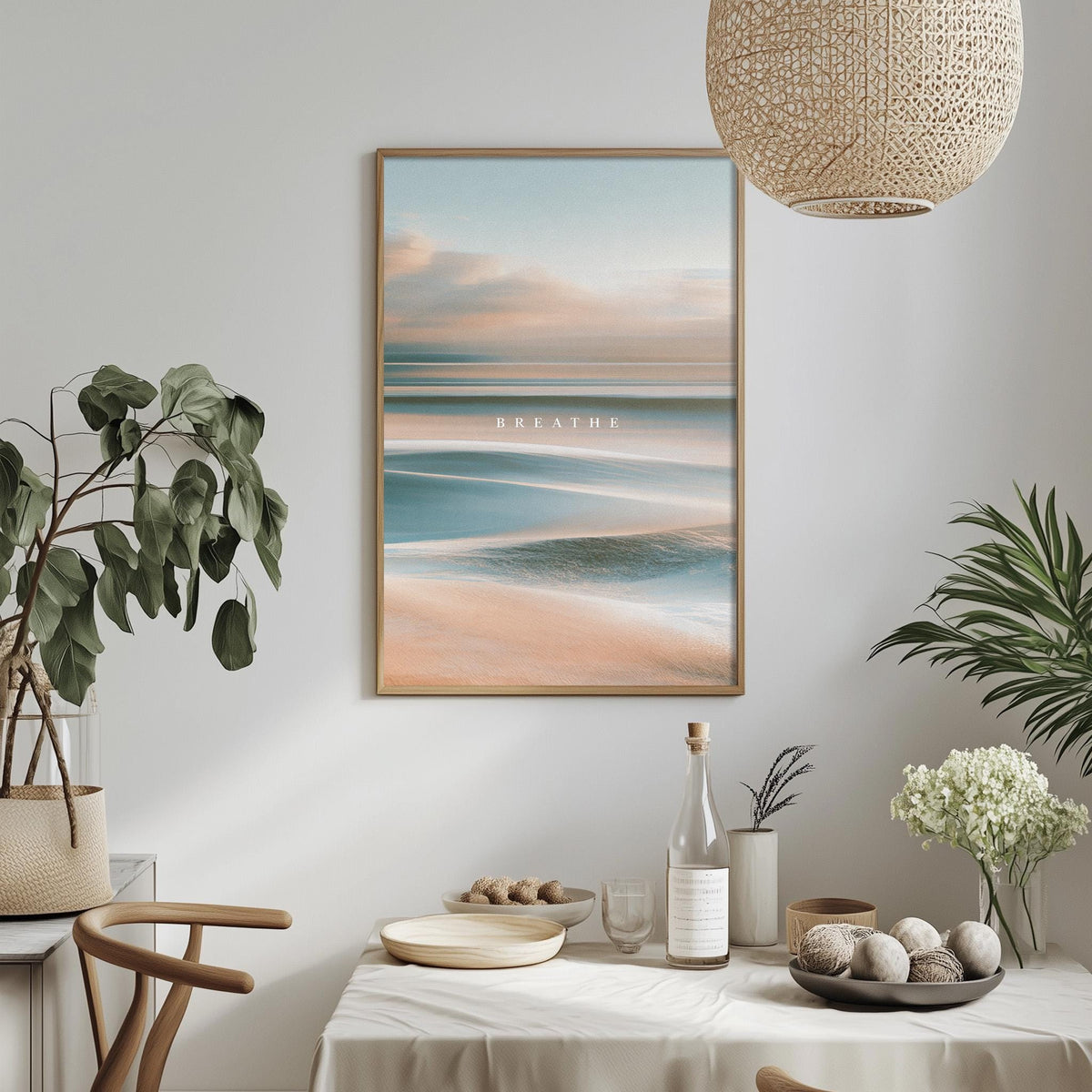 a serene and calming indoor setting with a framed picture of a beach scene hanging on the wall, a dining table with a bowl of fruit, a bottle of wine, and a potted plant.