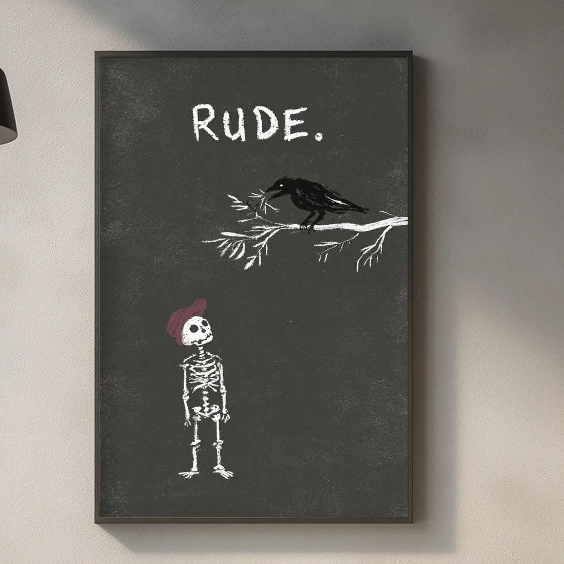 a kitchen counter with various items such as a cutting board, a bottle, and a plant. Above the counter, there is a framed artwork depicting a skeleton wearing a red hat and a bird, with the word "Rude" written on the artwork.