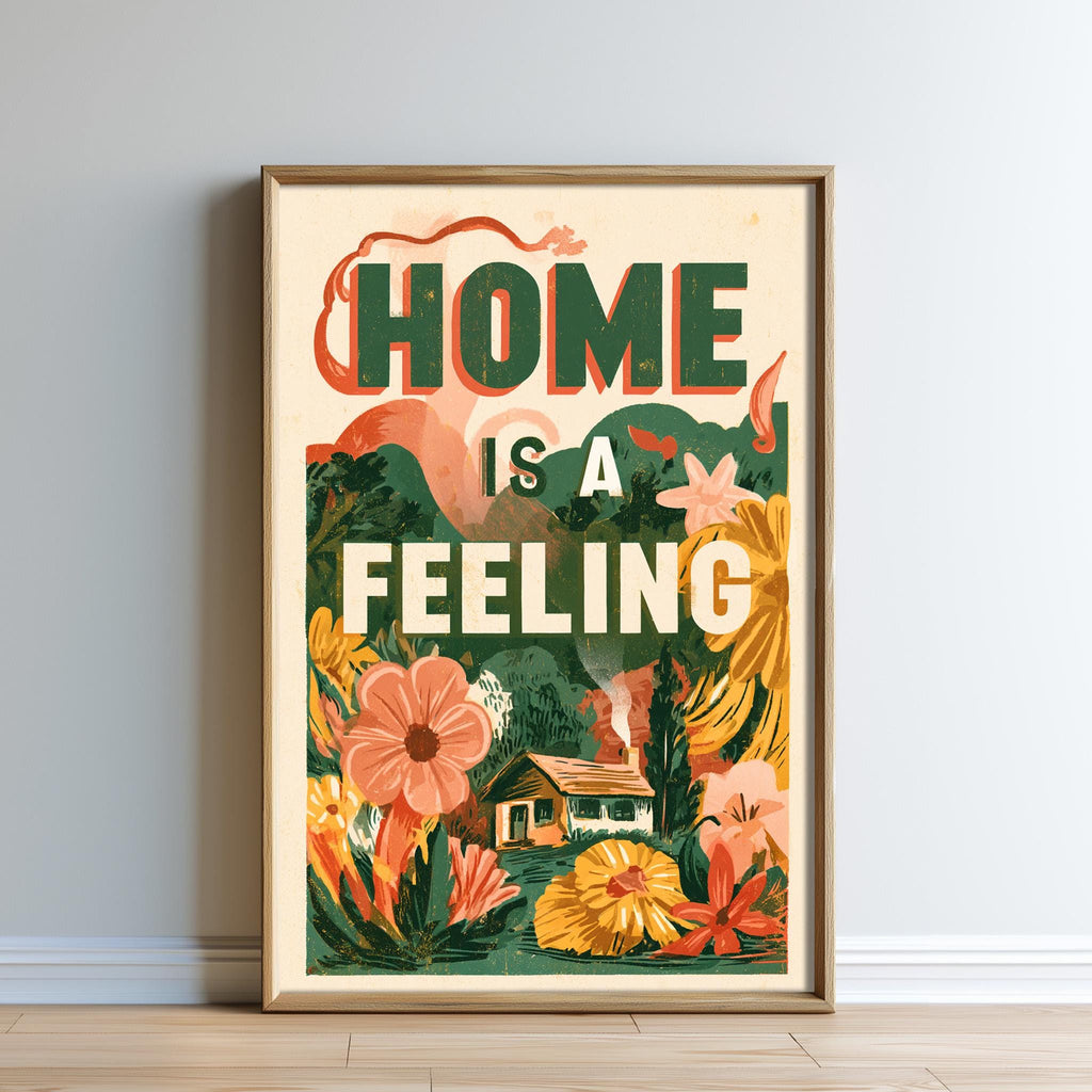 The image is a framed poster with a colorful illustration of flowers and a house, along with the text "HOME IS A FEELING" prominently displayed.