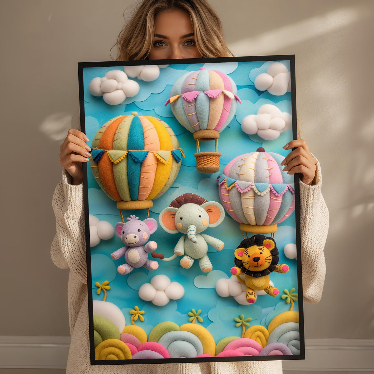 A woman holds up a framed artwork depicting colorful hot air balloons, elephants, and a lion against a blue sky with clouds.