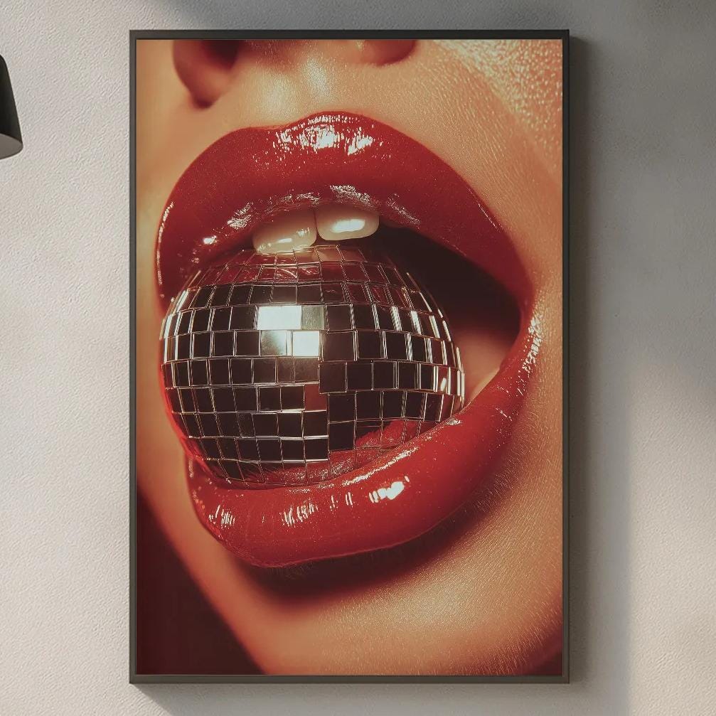 a kitchen counter with various kitchen items, including a cutting board, a bottle, and a bowl. Above the counter, there is a framed image of a woman's lips with a disco ball, creating a visually striking and modern design element.