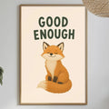 a framed poster of a cartoon fox with the text "GOOD ENOUGH" above it, hanging on a wall above a dining table with various items on it.