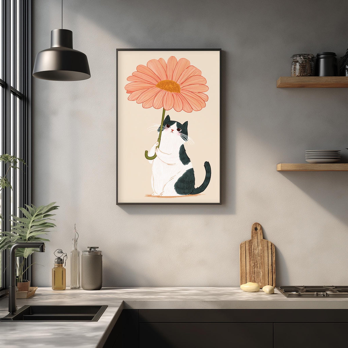 a kitchen counter with a framed illustration of a cat holding a large pink flower, which is hanging on the wall above the counter.