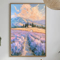 a dining table with a white tablecloth, a vase of white flowers, a bottle of wine, and a bowl of fruit. Above the table, there is a framed painting of a field with purple flowers and a winding path leading to a mountain in the distance.