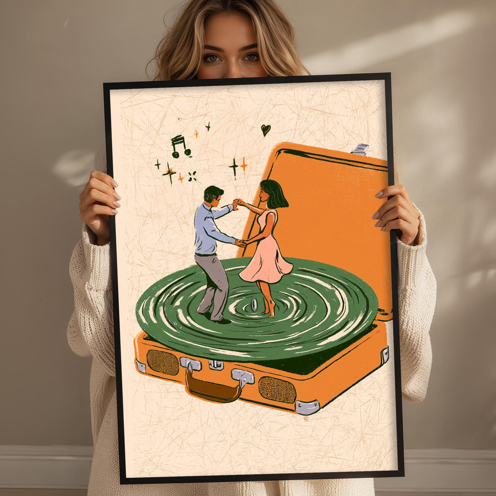 A woman holds up a framed illustration depicting a man and a woman dancing on a turntable.