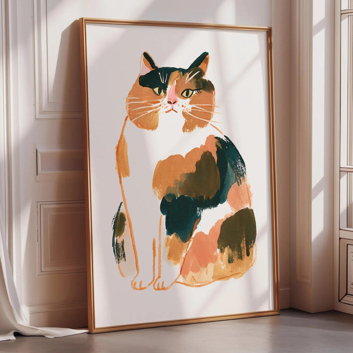 A framed illustration of a calico cat is displayed on a wall in a room with sunlight streaming in from a window.