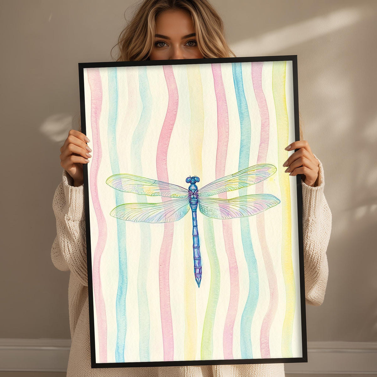 A woman is holding up a framed picture of a colorful dragonfly.