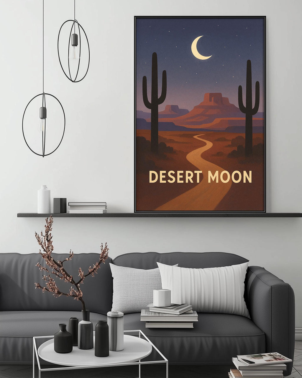 a living room with a gray sofa, a coffee table, and a framed poster of a desert landscape with a crescent moon and mountains in the background.
