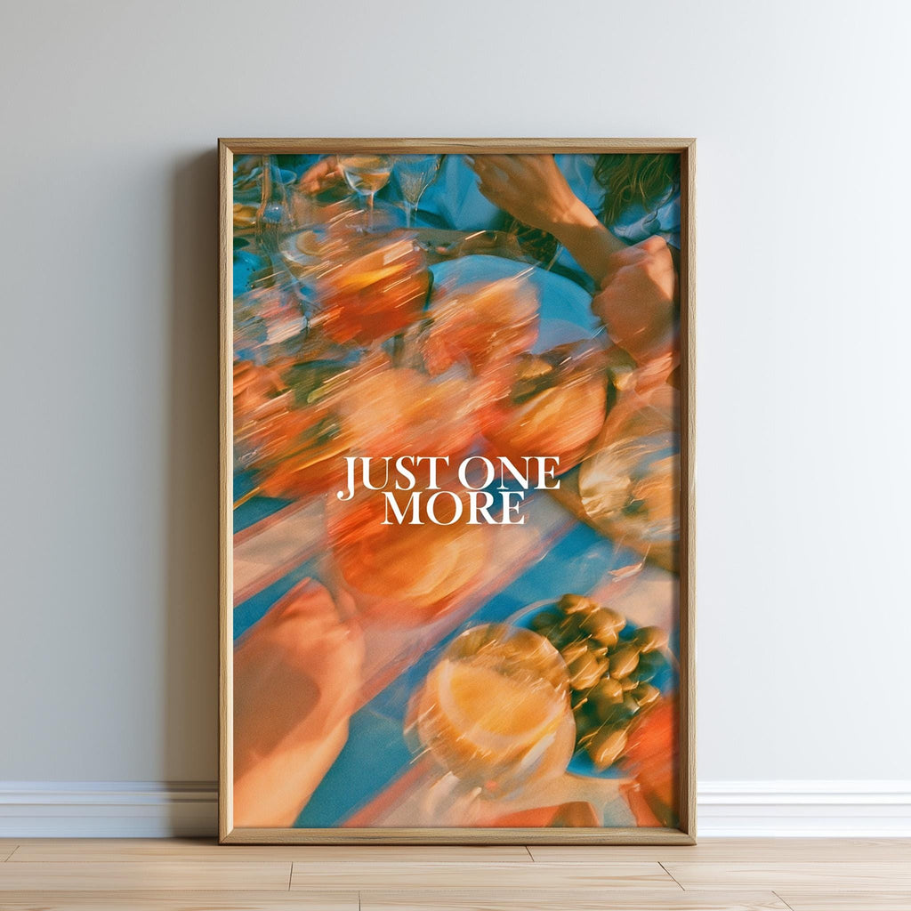The image is a framed poster with a blurred background featuring various fruits, such as oranges and grapes, and the text "JUST ONE MORE" prominently displayed in the center.