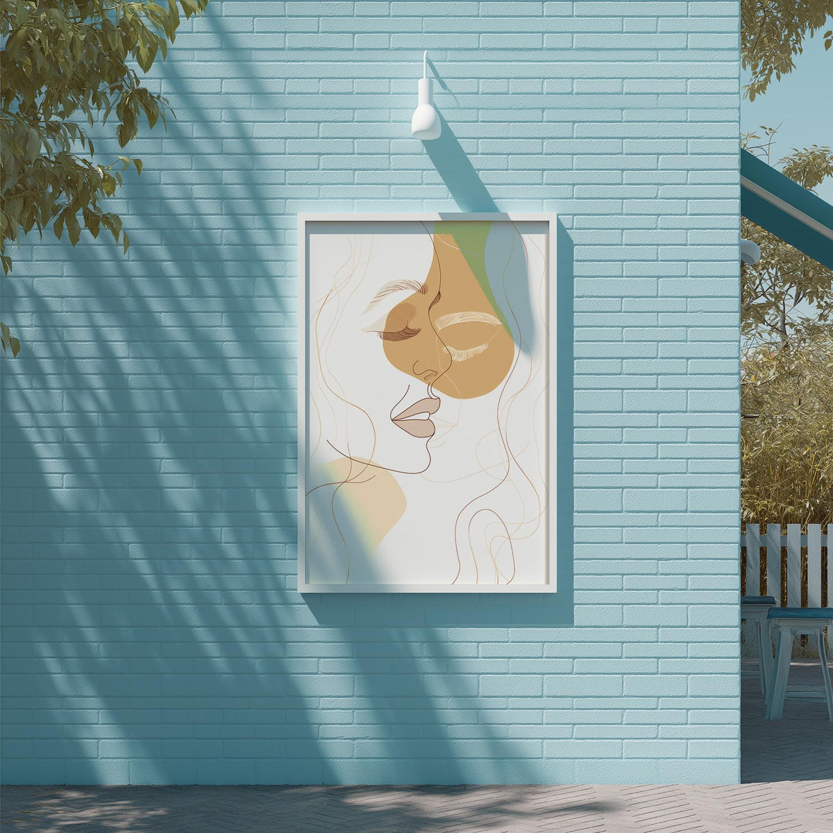 a framed artwork of a woman's face on a blue brick wall, with a white light fixture above it.