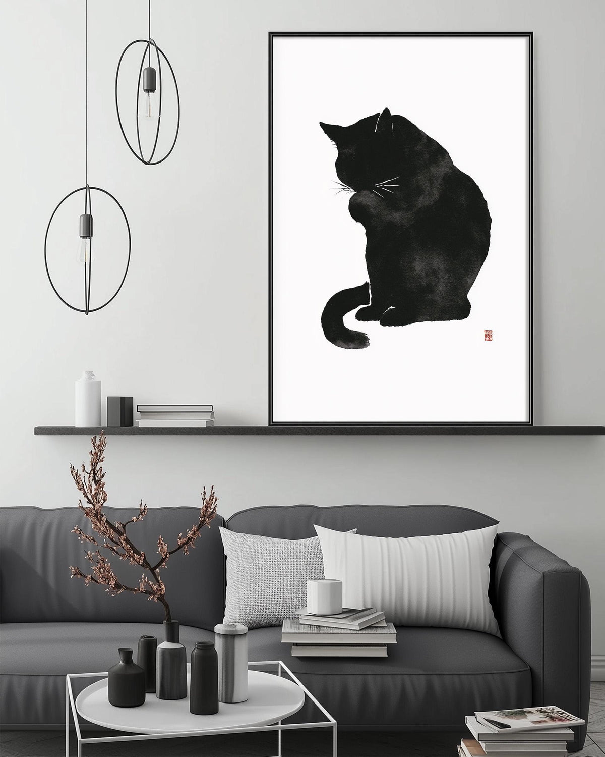 a black and white cat sitting on a couch, with a framed print of the cat above it. The room has a minimalist and modern design, with a gray couch, a coffee table, and a shelf with decorative items.