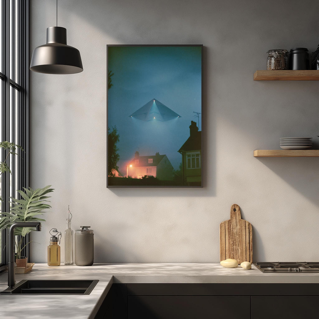 a kitchen scene with a framed picture of a house and a triangular object in the sky above it, hanging on the wall.