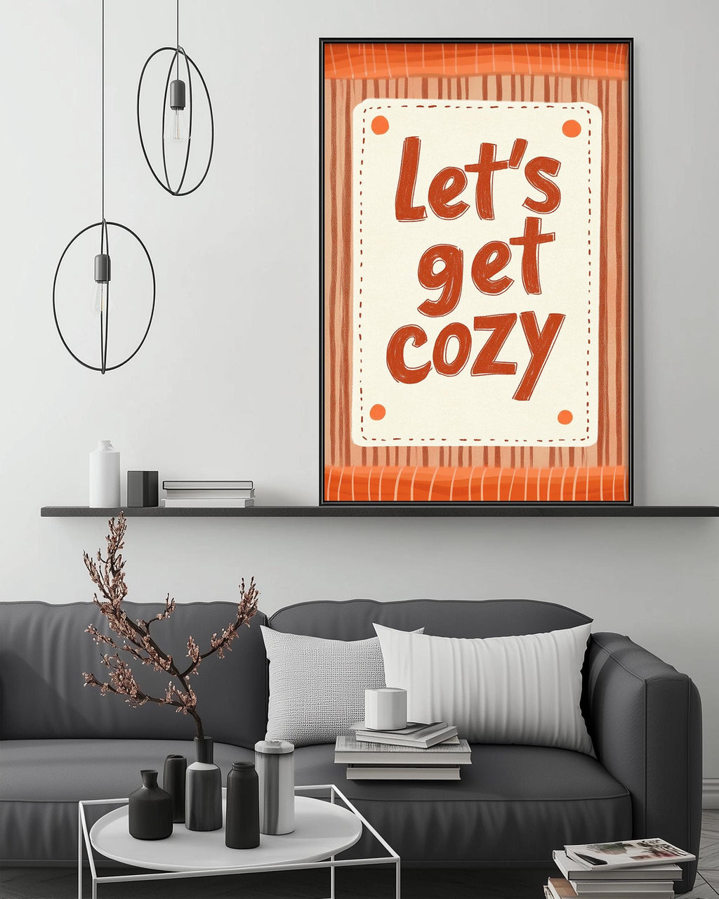 a cozy living room with a gray couch, a coffee table, and a framed poster with the text "Let's get cozy" displayed on the wall above the couch.