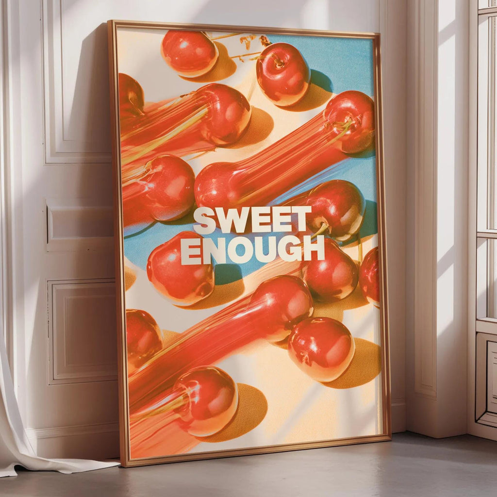 a poster with a vibrant design of red and orange fruits, including apples and carrots, arranged in a visually appealing manner. The poster is framed and placed on a wall, creating a striking and eye-catching display.