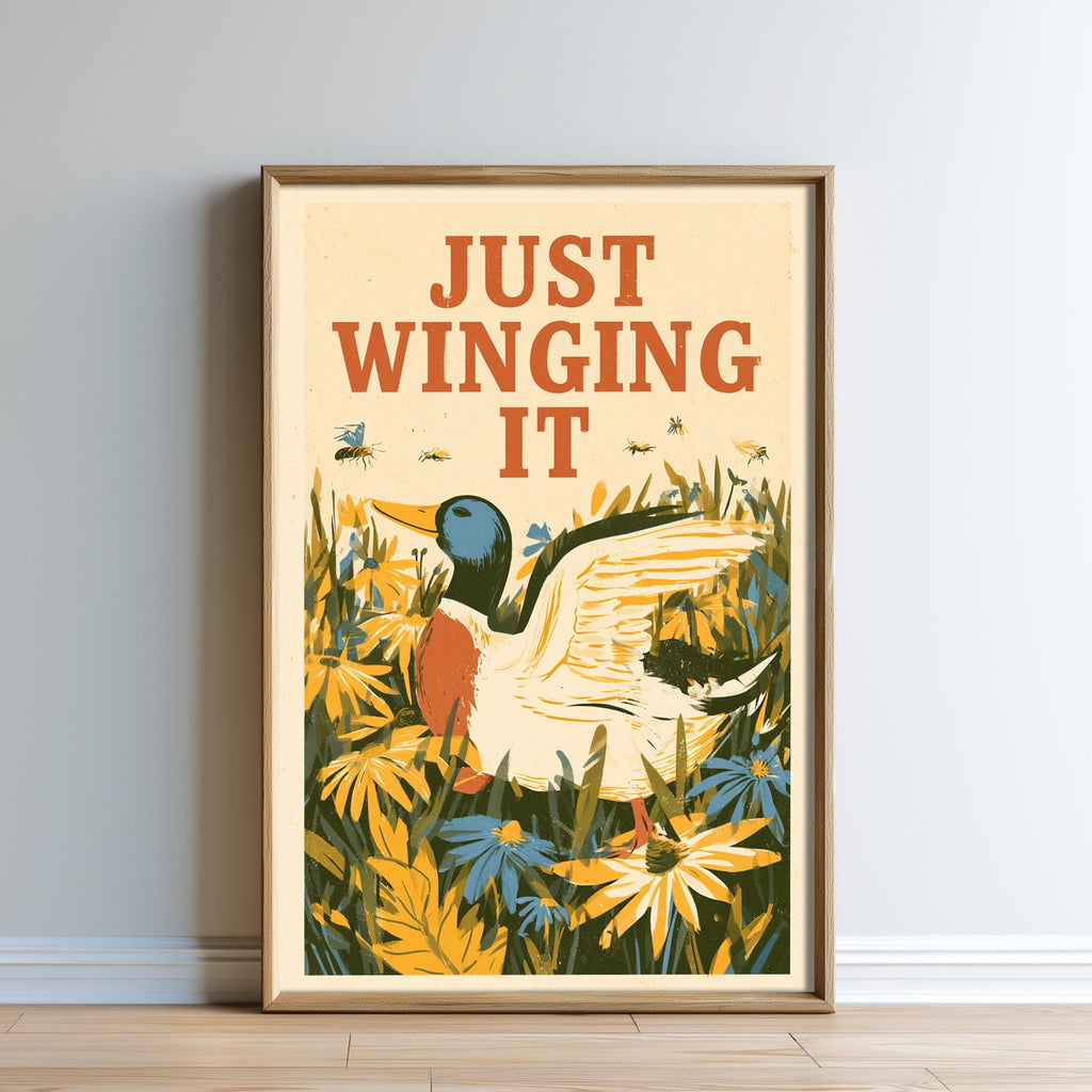 The image is a framed poster with a duck surrounded by flowers and plants, with the text "JUST WINGING IT" written above it.